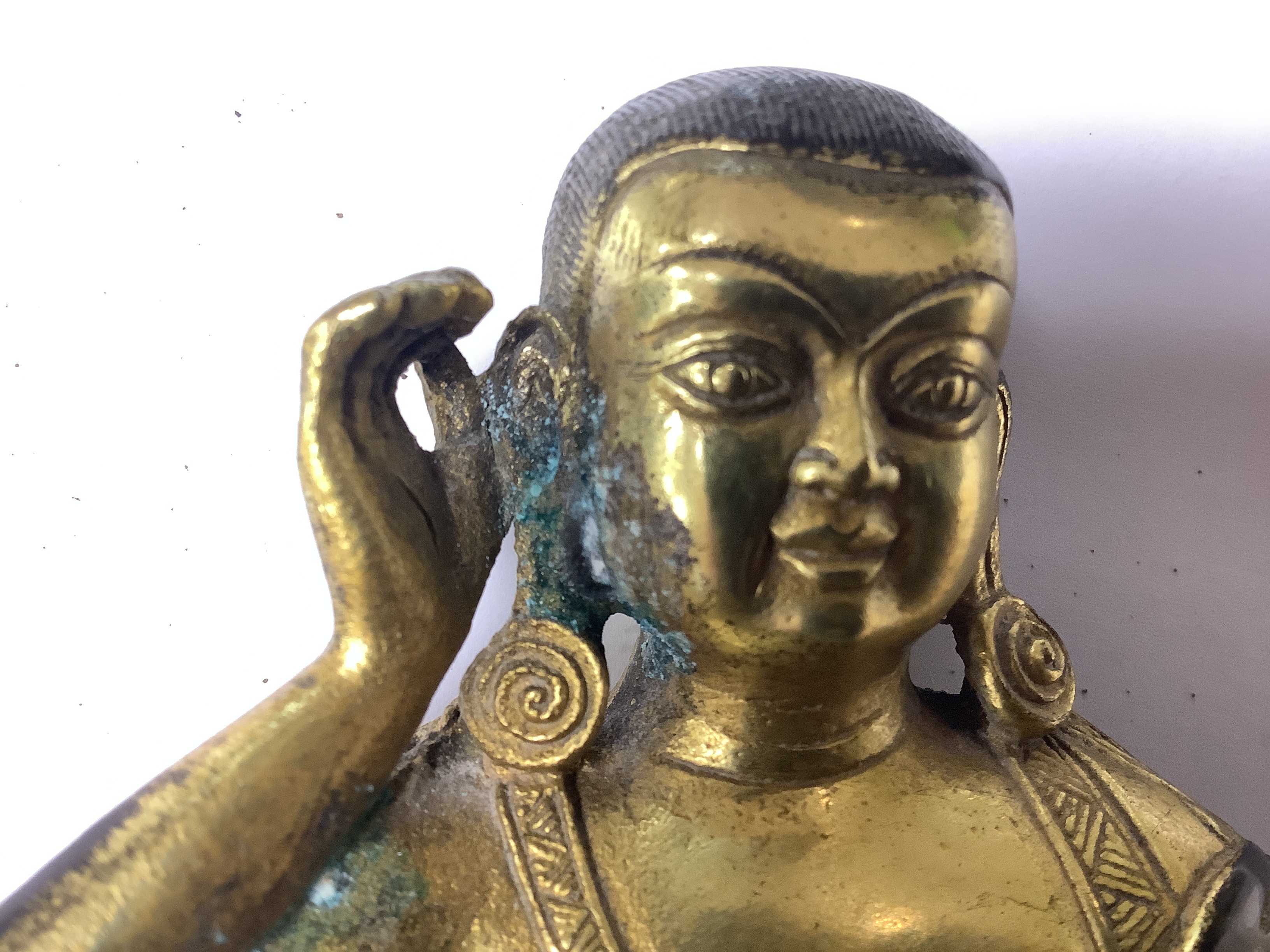 A Sino-Tibetan gilt bronze seated figure of Milarepa, 14cm high